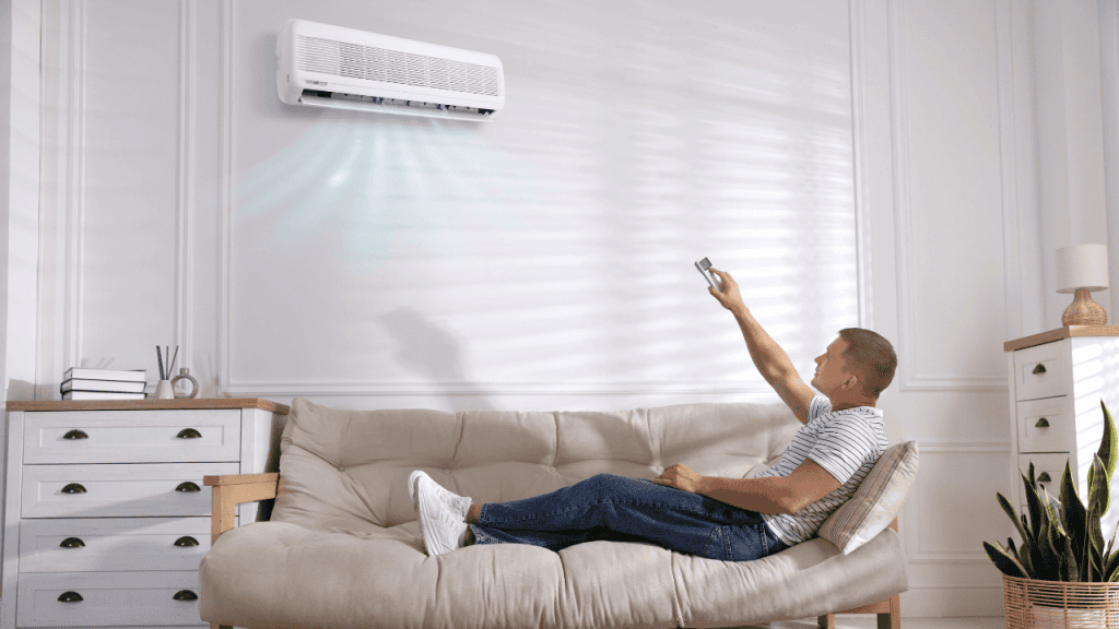 Homeowner adjusting a wall-mounted air conditioner with a remote control