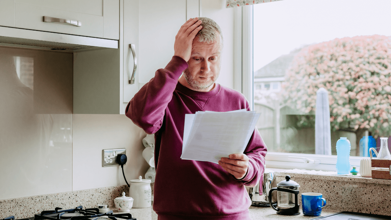 Homeowner stressed while reviewing a high energy bill caused by an inefficient air conditioner