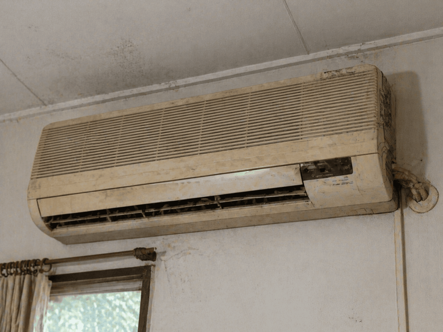 Old, outdated wall-mounted air conditioner in need of replacement